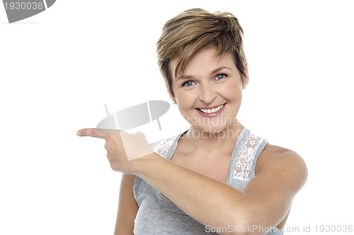 Image of Pretty woman pointing towards copy space area