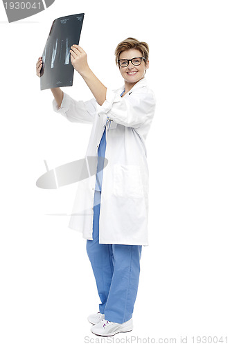 Image of Smiling middle aged doctor holding up x-ray sheet