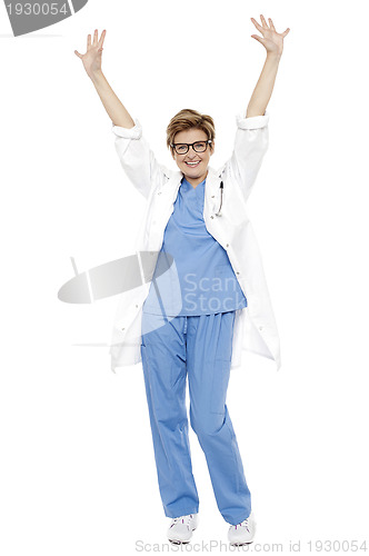 Image of Cheerful doctor raising her hands up in celebration