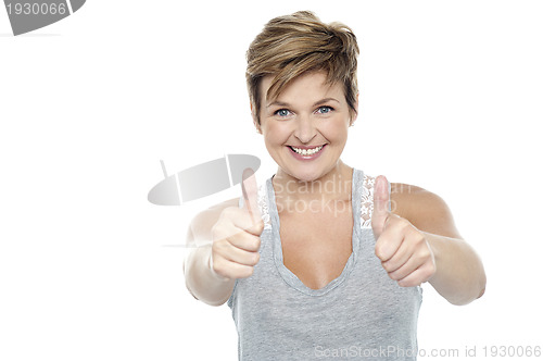 Image of Excited middle aged lady showing double thumbs up