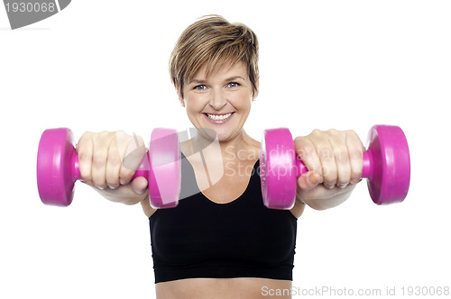 Image of Lady holding pink dumbbells. Arms outstretched