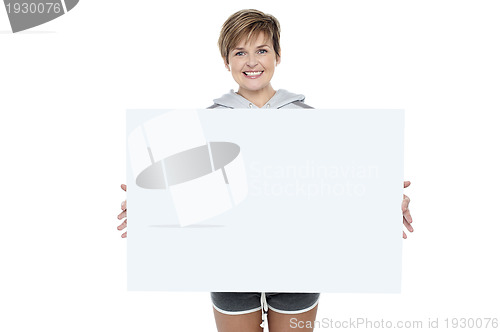 Image of Charming young woman holding white ad board