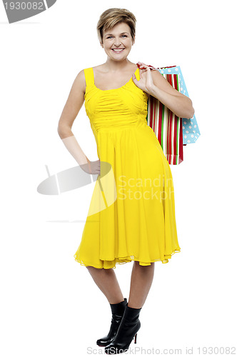 Image of Portrait of a happy woman carrying shopping bags