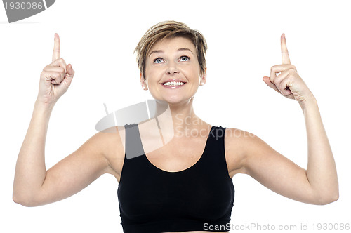 Image of Woman looking and pointing upwards with both hands