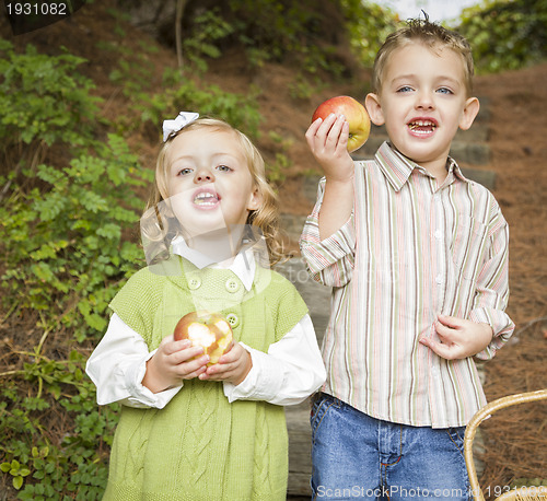 Image of Adorable Children Eating Red Apples Outside