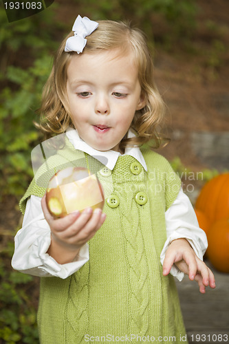 Image of Adorable Child Girl Eating Red Apple Outside