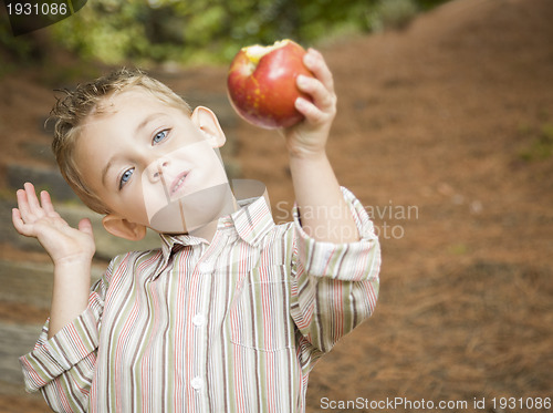 Image of Adorable Child Boy Eating Red Apple Outside