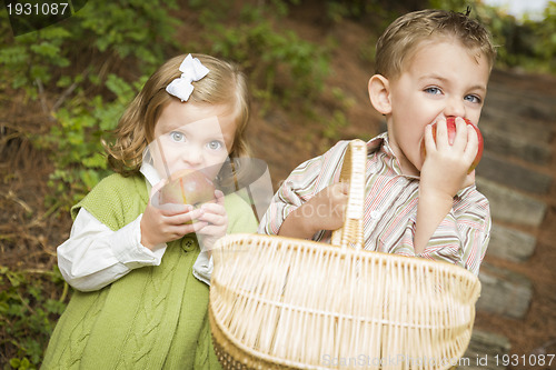 Image of Adorable Children Eating Red Apples Outside