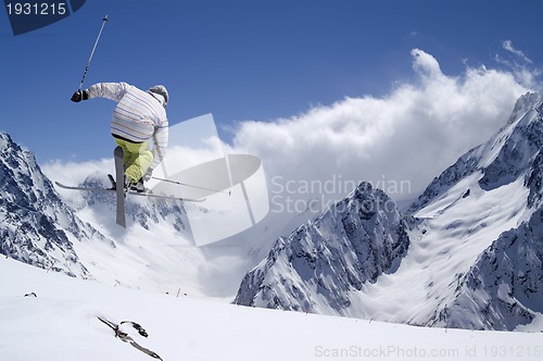 Image of Freestyle ski jumper with crossed skis in high mountains