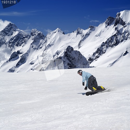 Image of Snowboarder on ski piste in high mountains