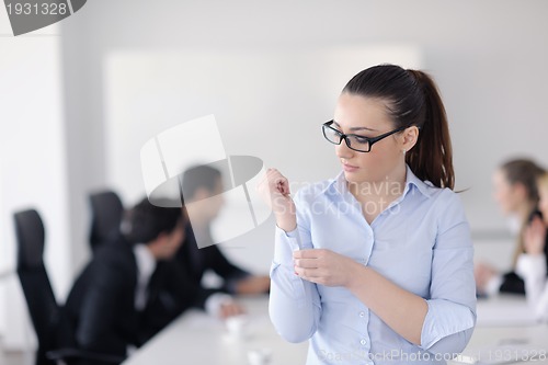Image of business woman standing with her staff in background