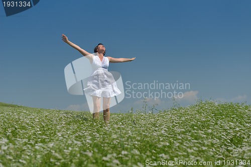 Image of Young happy woman in green field