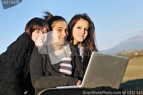 Image of group of teens working on laptop outdoor