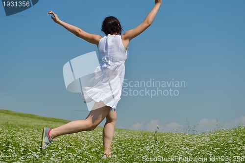 Image of Young happy woman in green field