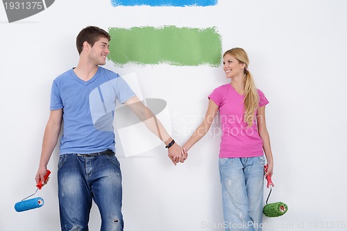 Image of happy couple paint wall at new home