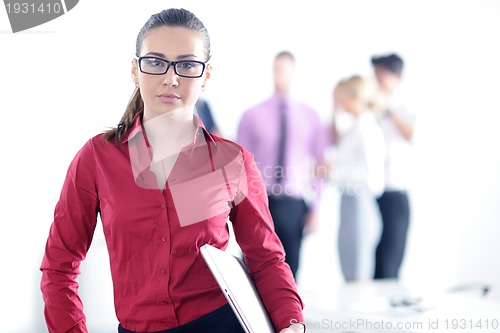 Image of business woman standing with her staff in background
