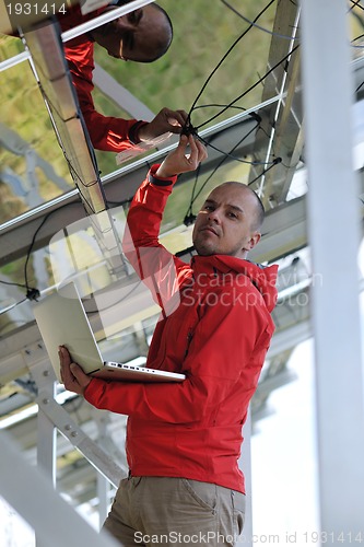 Image of engineer using laptop at solar panels plant field