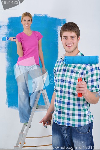 Image of happy couple paint wall at new home