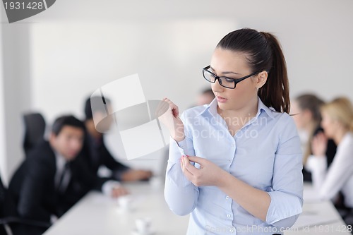 Image of business woman standing with her staff in background