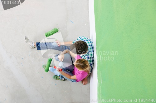 Image of happy smiling woman painting interior of house