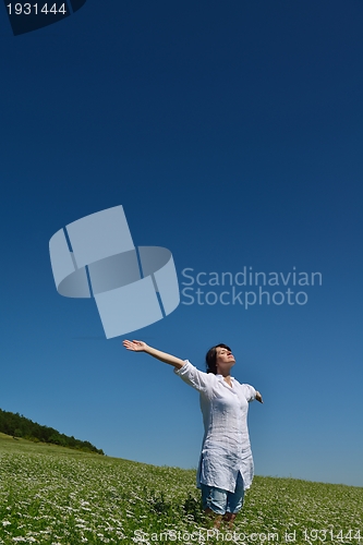 Image of Young happy woman in green field