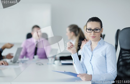 Image of business woman standing with her staff in background