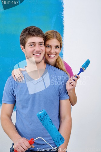 Image of happy couple paint wall at new home