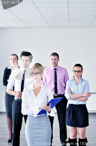 Image of business woman standing with her staff in background