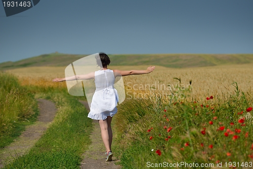 Image of young woman in wheat field at summer