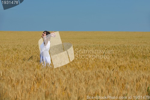 Image of young woman in wheat field at summer