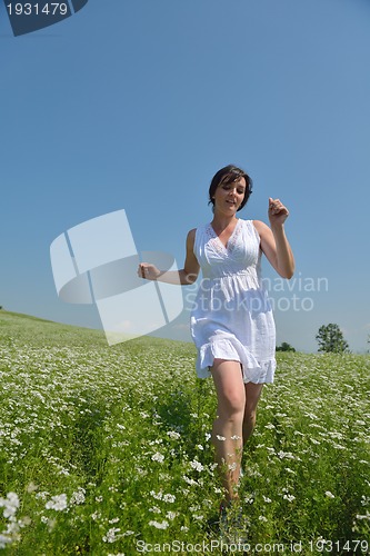 Image of Young happy woman in green field