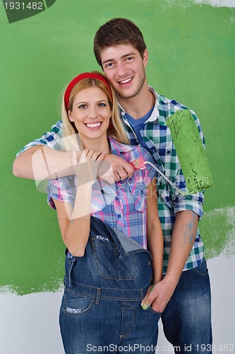 Image of happy couple paint wall at new home