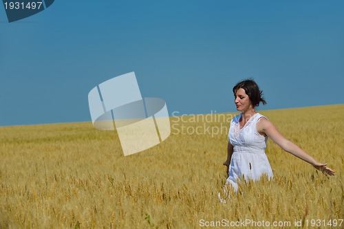 Image of young woman in wheat field at summer
