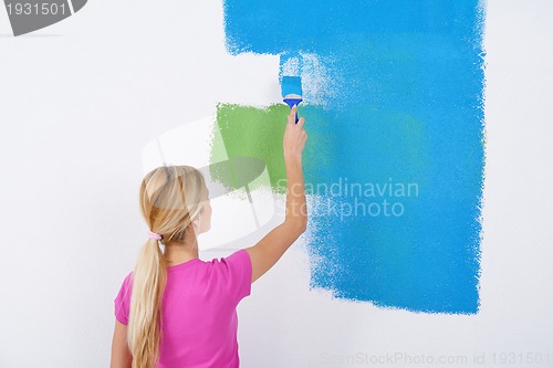 Image of happy couple paint wall at new home