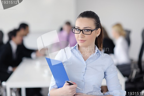 Image of business woman standing with her staff in background