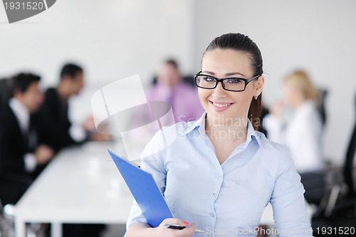 Image of business woman standing with her staff in background