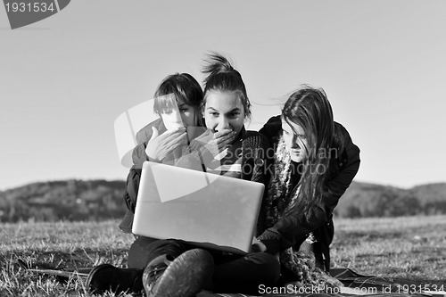 Image of group of teens working on laptop outdoor