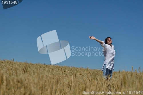Image of young woman in wheat field at summer