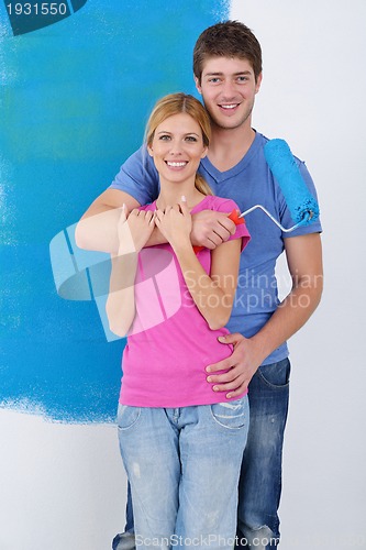 Image of happy couple paint wall at new home