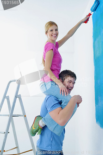 Image of happy couple paint wall at new home