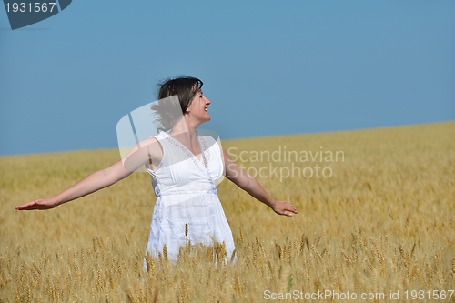 Image of young woman in wheat field at summer