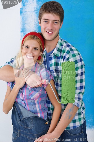 Image of happy couple paint wall at new home