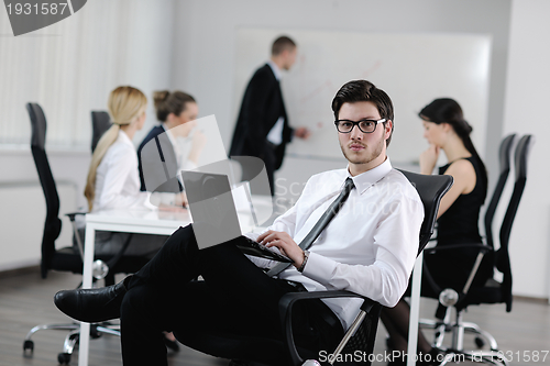 Image of handsome young business man with colleagues in background