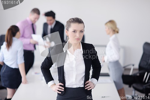 Image of business woman standing with her staff in background