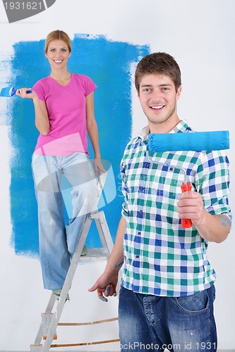 Image of happy couple paint wall at new home