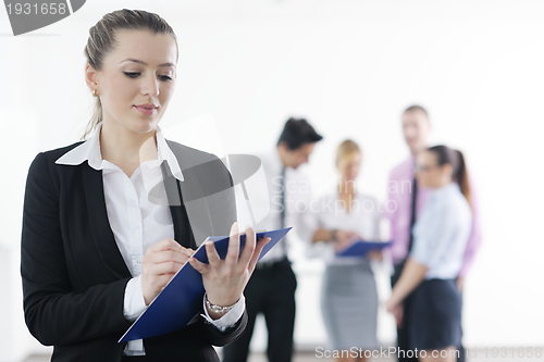 Image of business woman standing with her staff in background