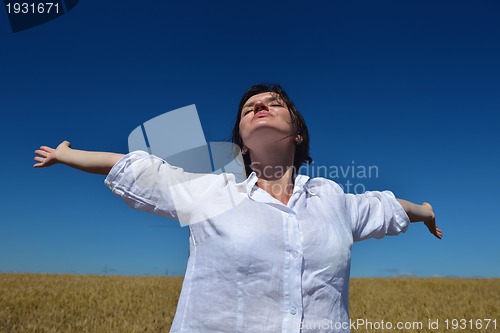Image of young woman in wheat field at summer
