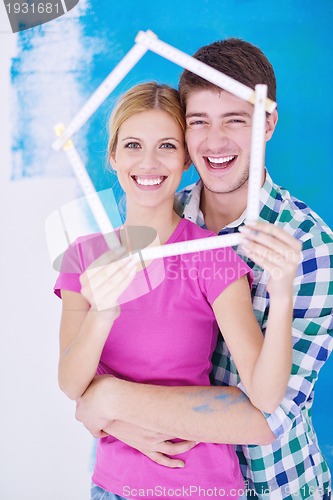 Image of happy couple paint wall at new home