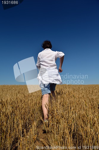 Image of young woman in wheat field at summer