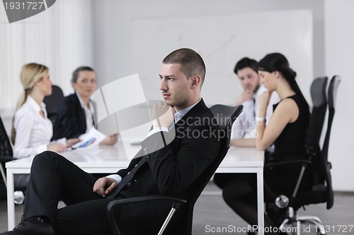 Image of handsome young business man with colleagues in background